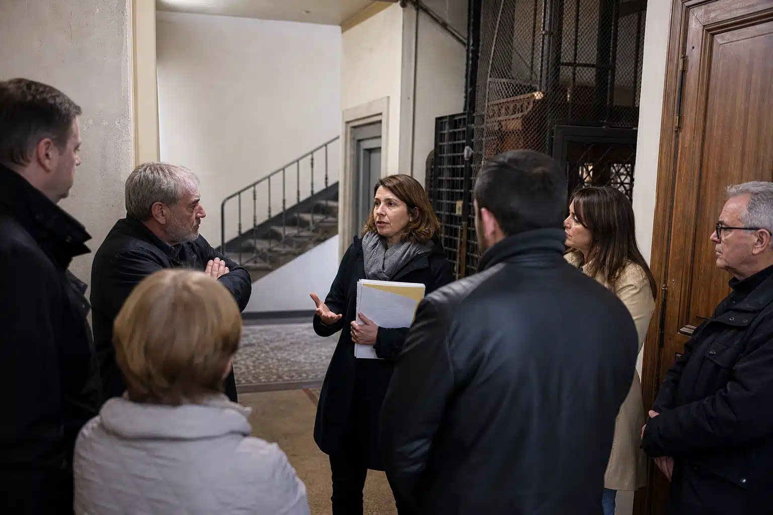 femme guidant un petit groupe près d'un escalier
